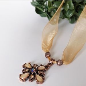 Chocker in a golden tone with cross detail.